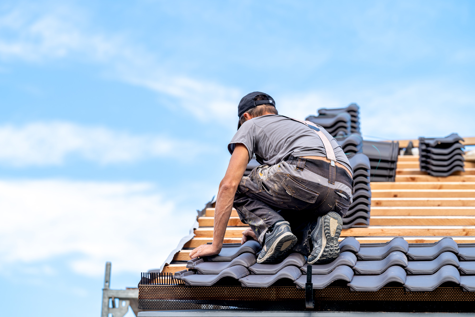 Roofer laying roof tiles